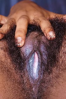 Sexy black girl rubs her big tits hairy twat on the bed